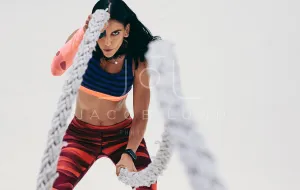 Close up of a fitness woman working out using battle ropes